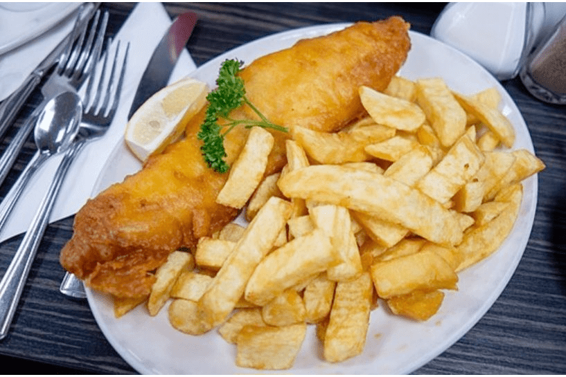 Fish and chips with lemon garnish.