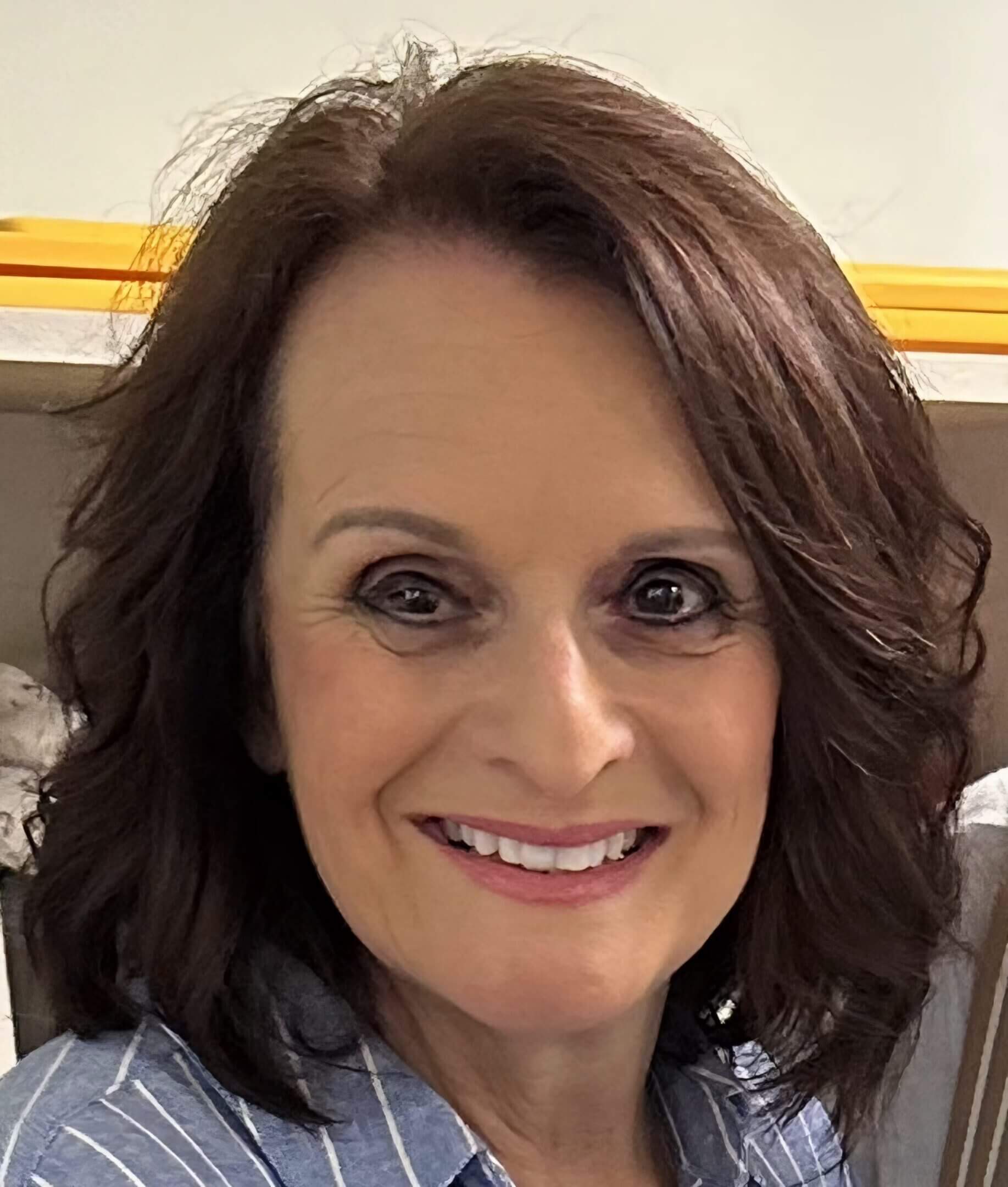 A smiling woman with shoulder-length brown hair.