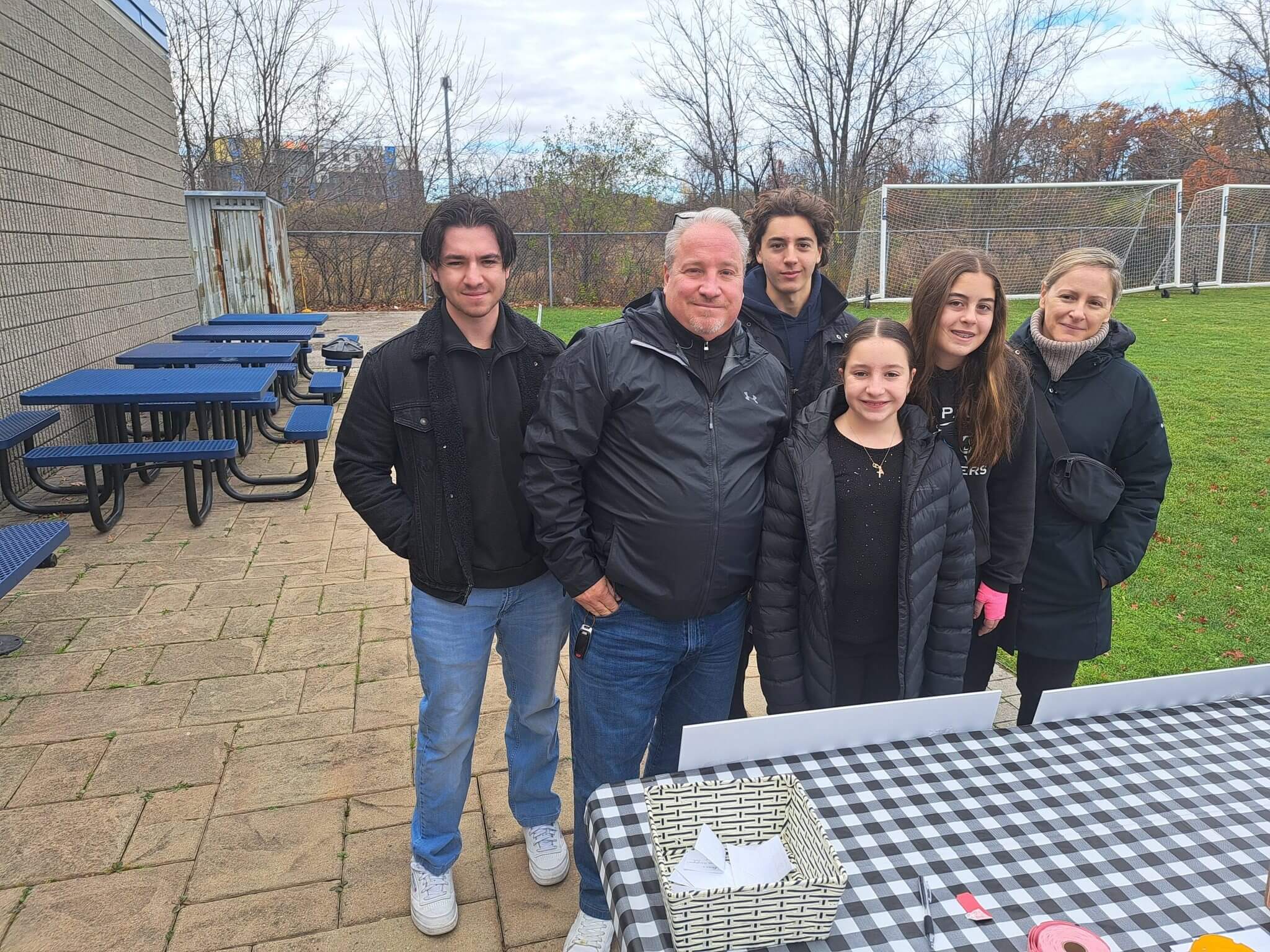 A group of six people posing outdoors on a chilly day.