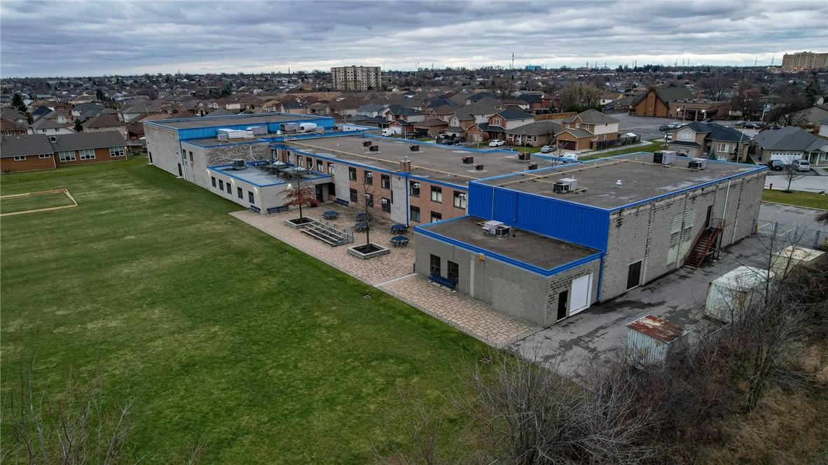 Aerial view of a residential complex with blue roofs and surrounding neighborhood.