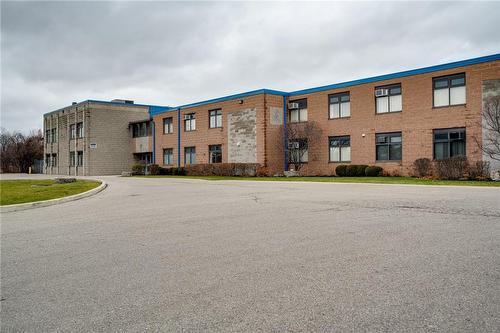 Exterior view of a two-story brick building with an entrance ramp and parking area.