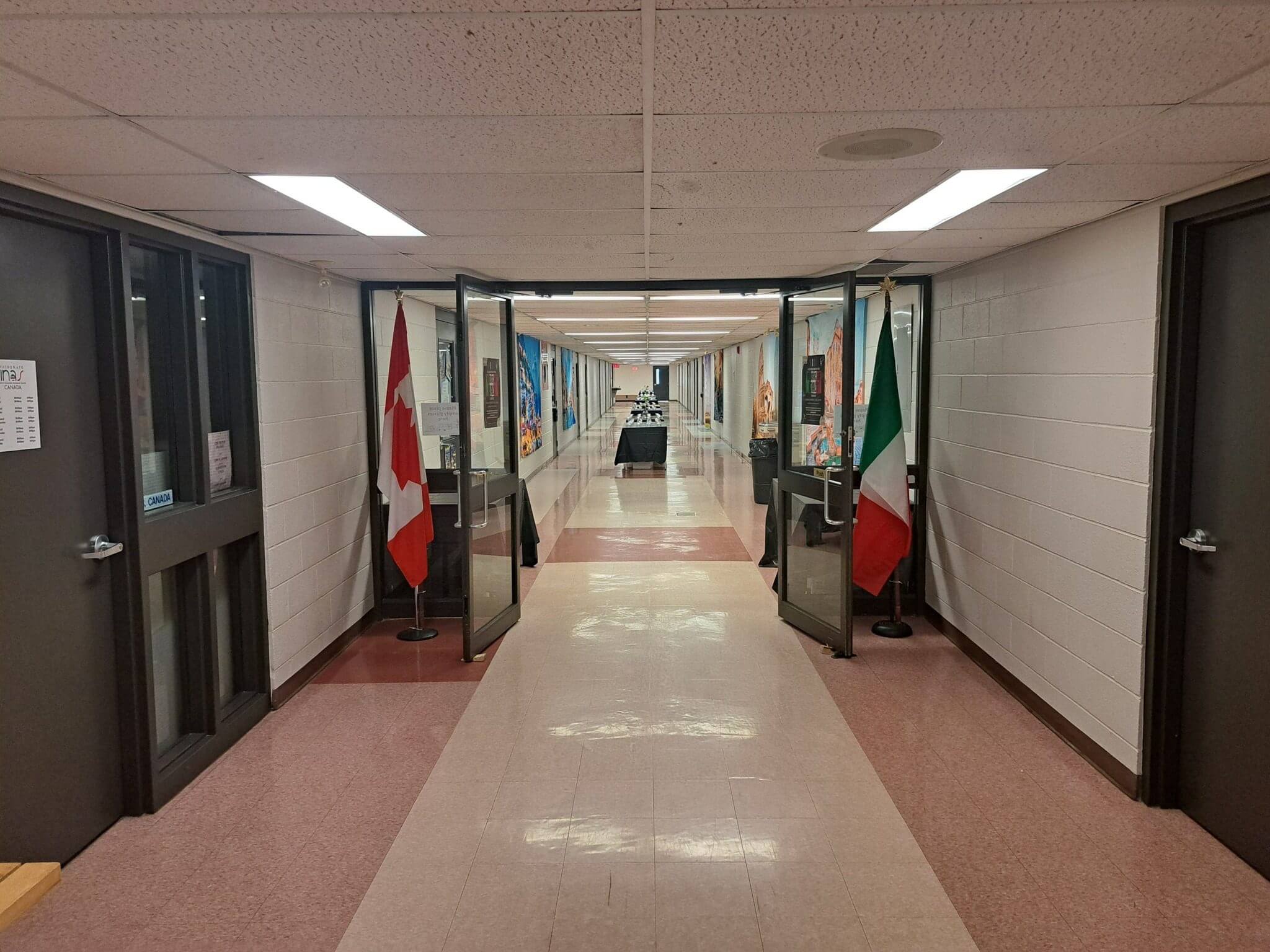 A hallway decorated with flags, including the Mexican flag.