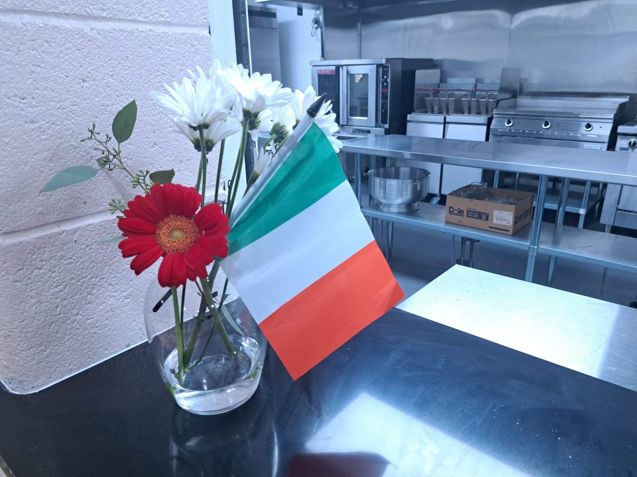 Irish flag in a vase with flowers on a table.
