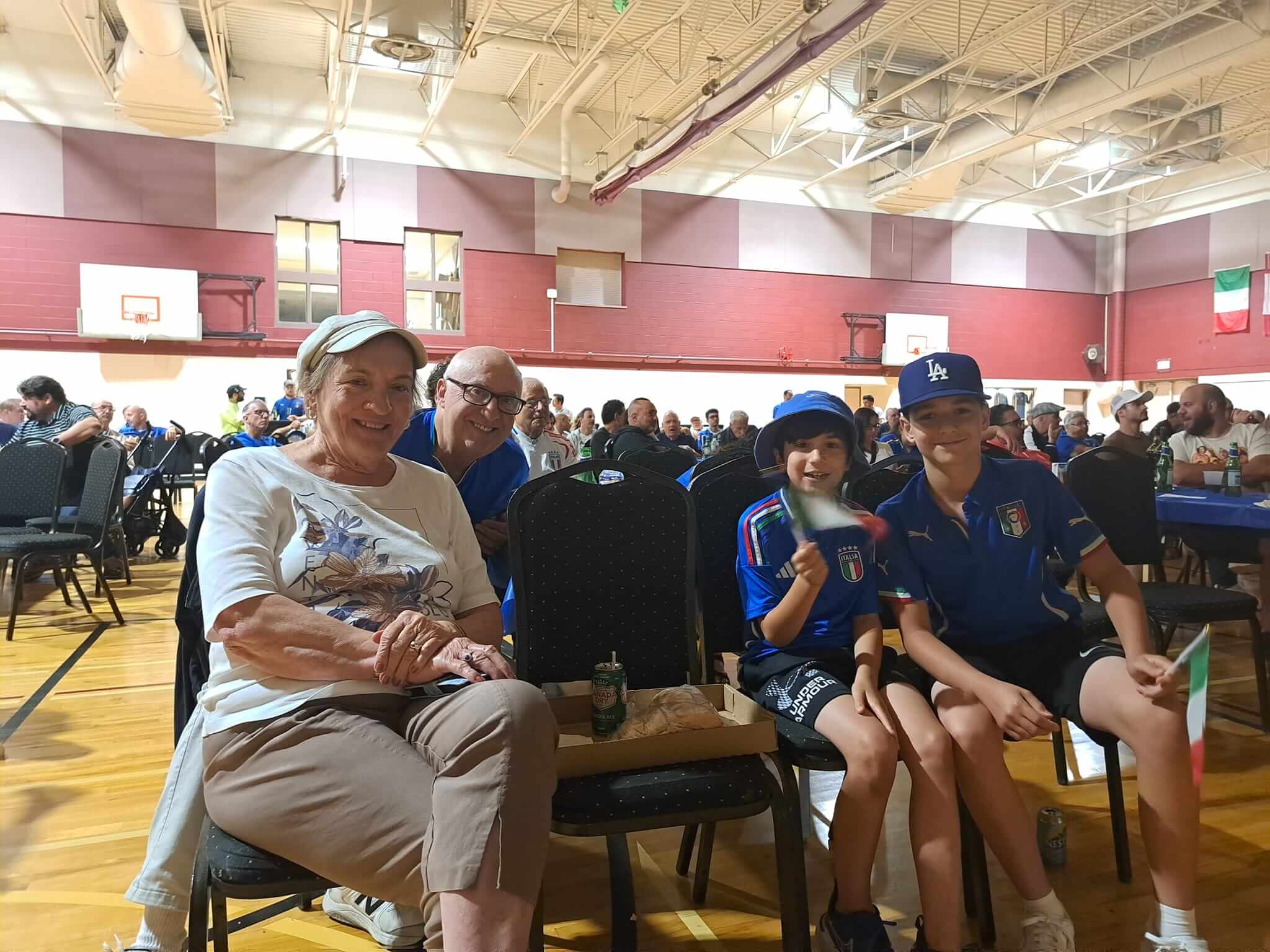 A group of elderly women sitting together in a gymnasium.