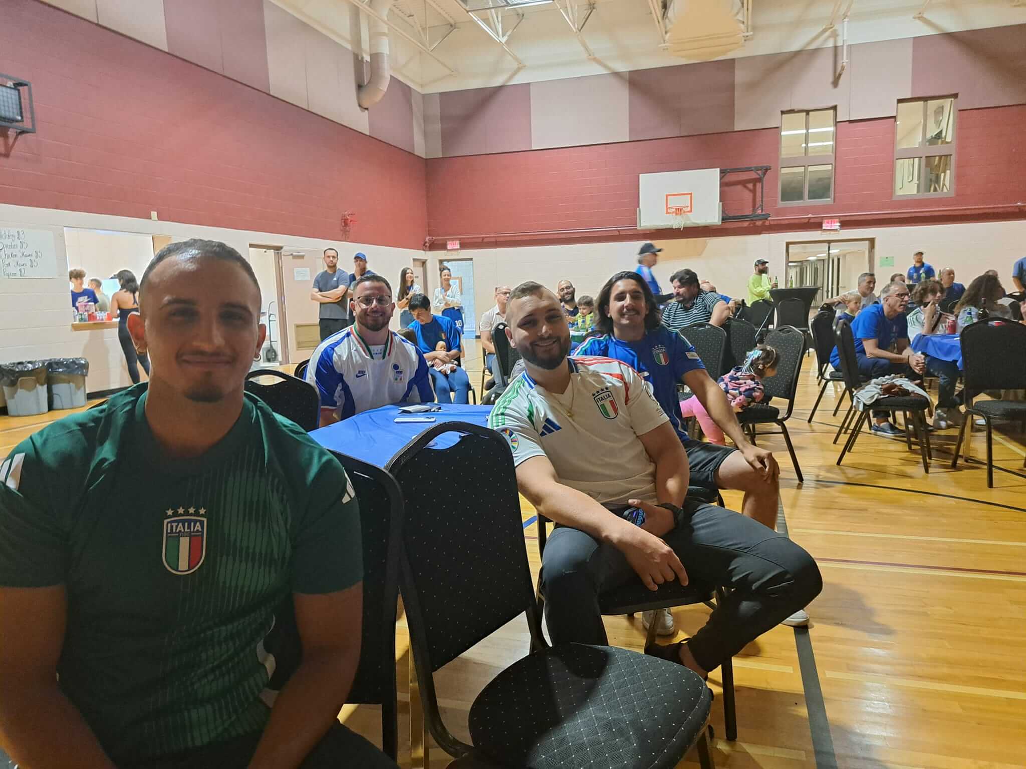 People seated in a gymnasium attending an event.