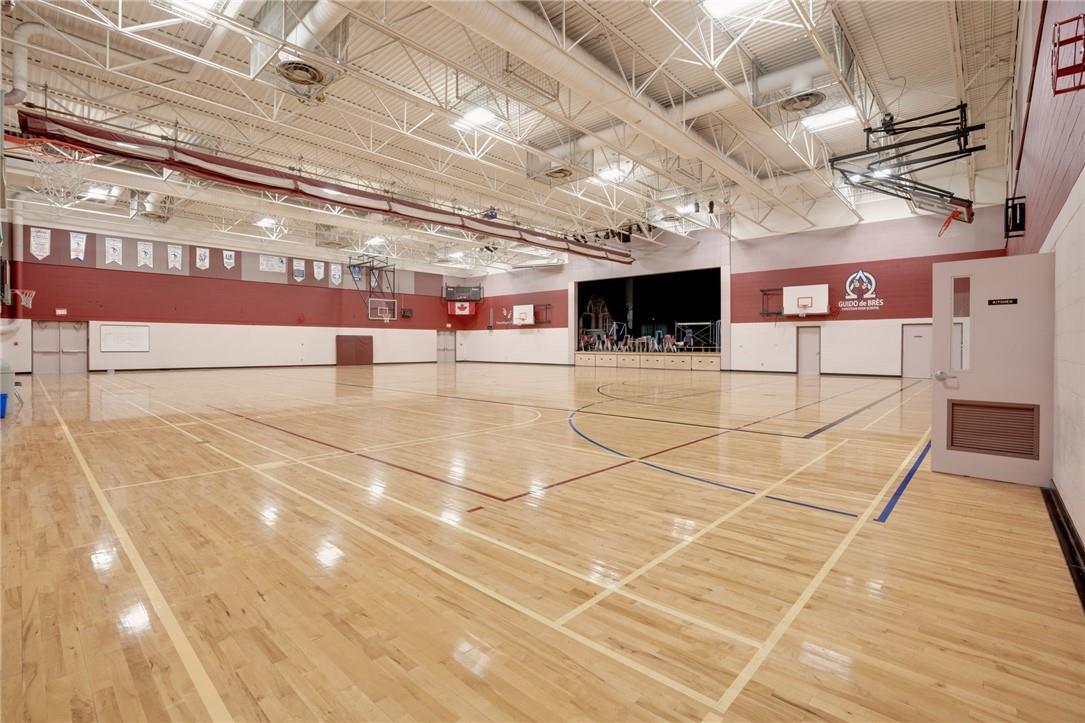 Empty indoor basketball court with polished wooden floor and high ceiling.