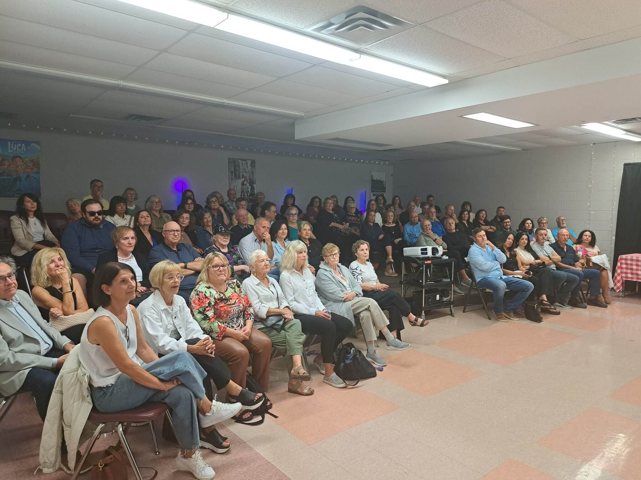 Audience attentively watching a presentation in a conference room.