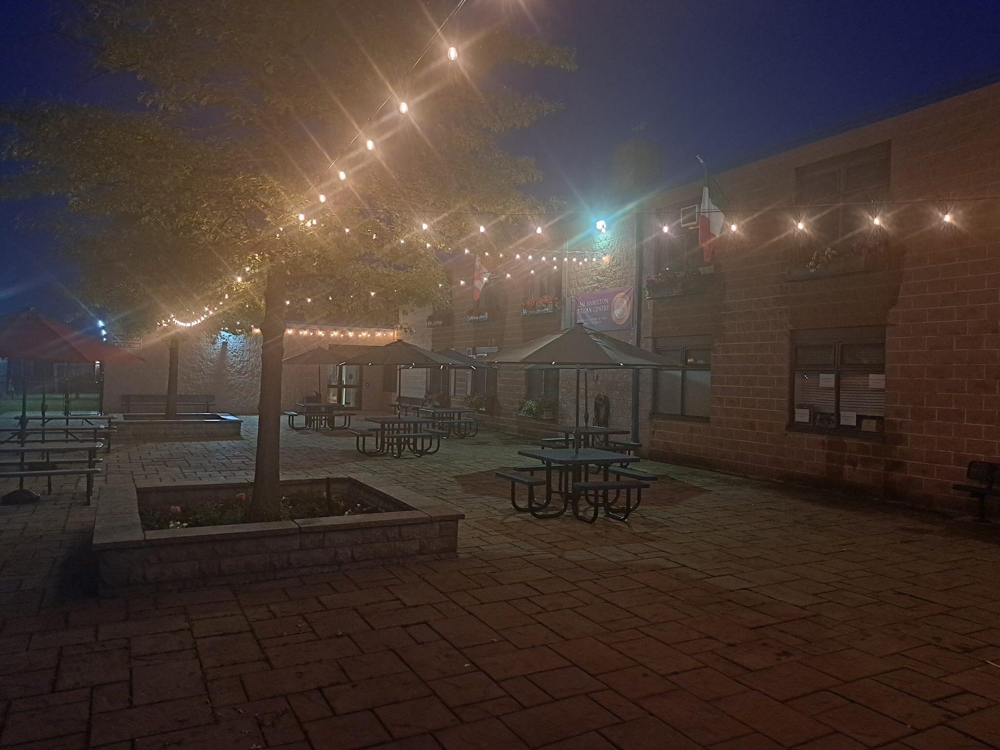 Outdoor seating area with string lights illuminating the evening.