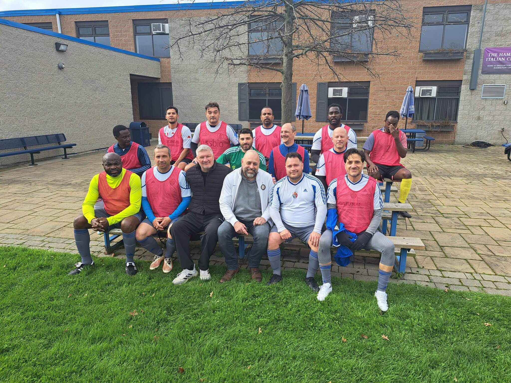 A group of people posing outdoors in sportswear and vests.