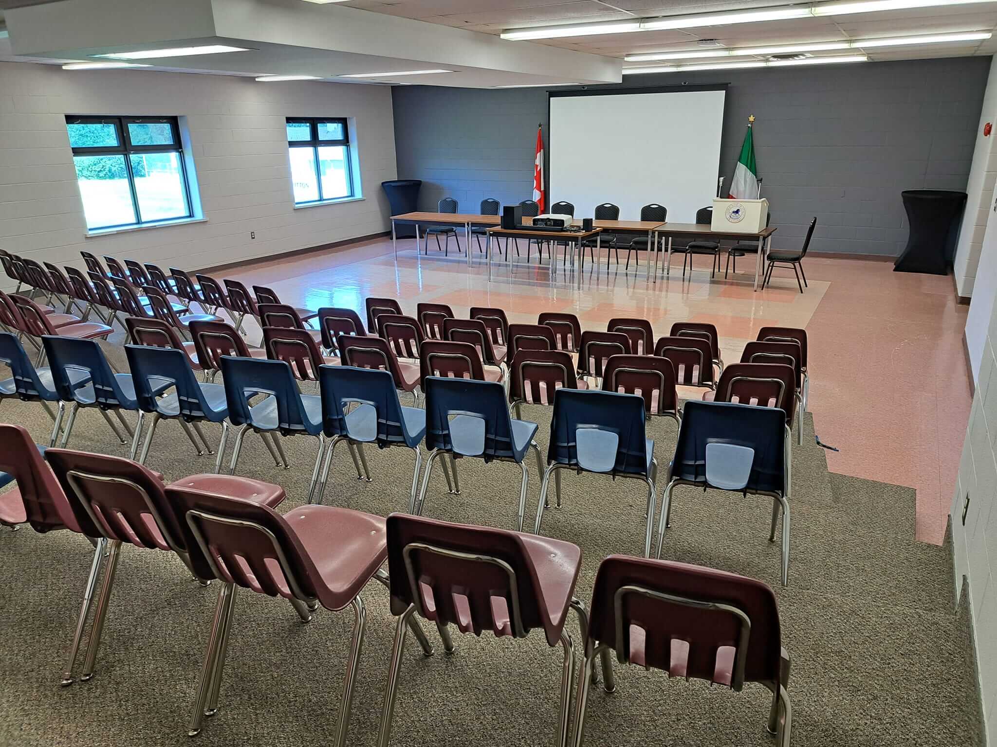 A conference room with rows of chairs and a large U-shaped table setup.