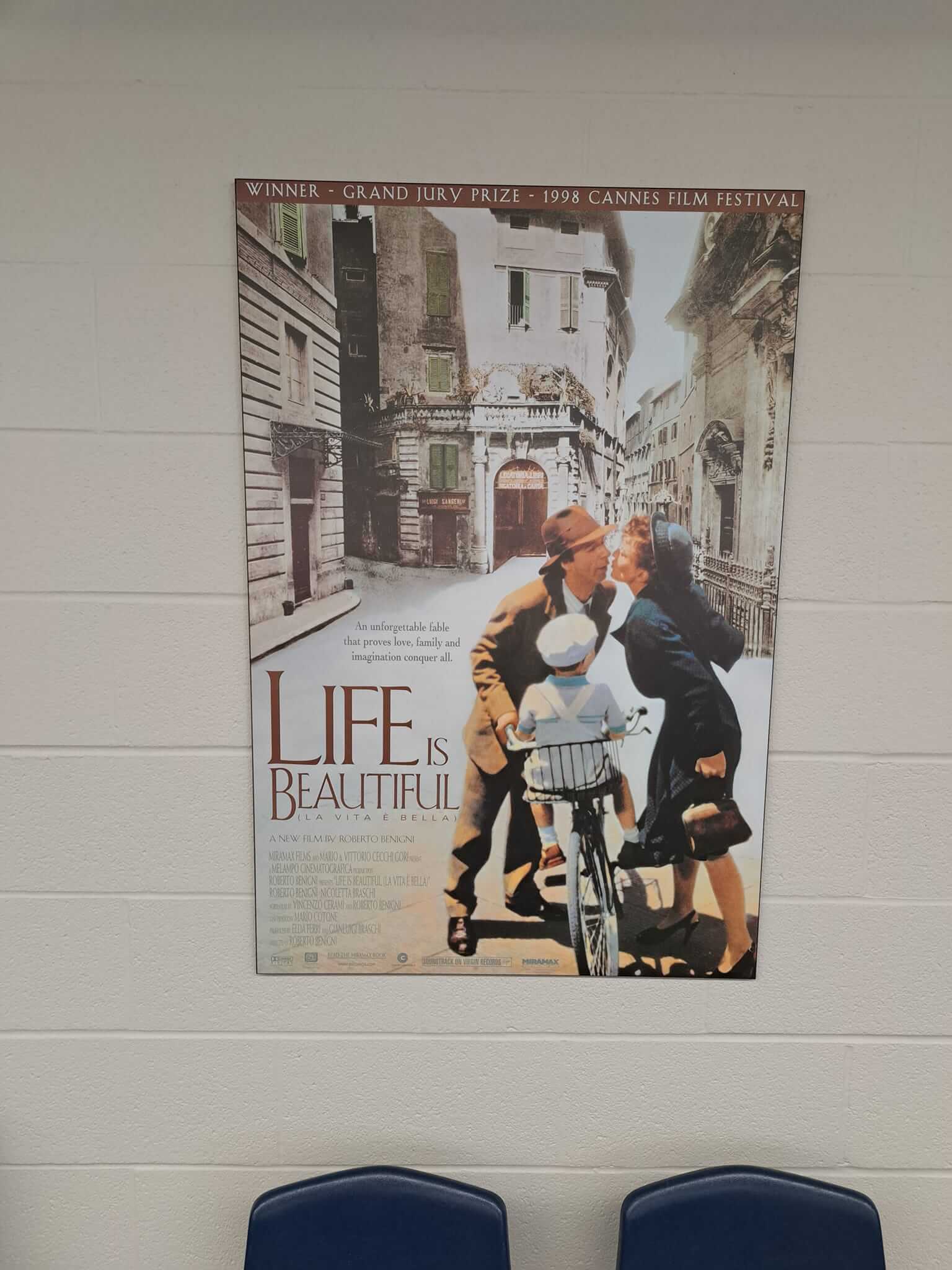Vintage-style poster of a couple with a bicycle in a European street.