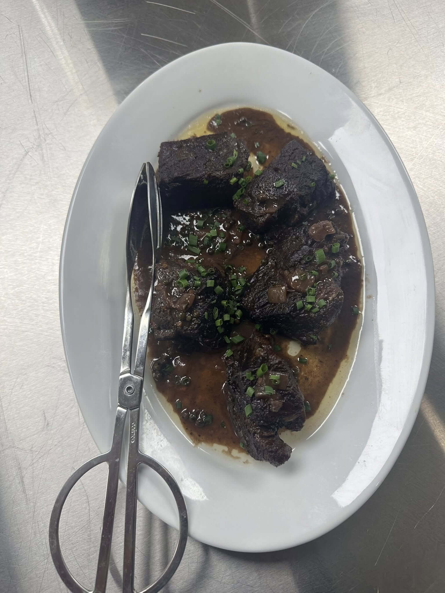 Plate of lamb chops garnished with herbs and sauce.