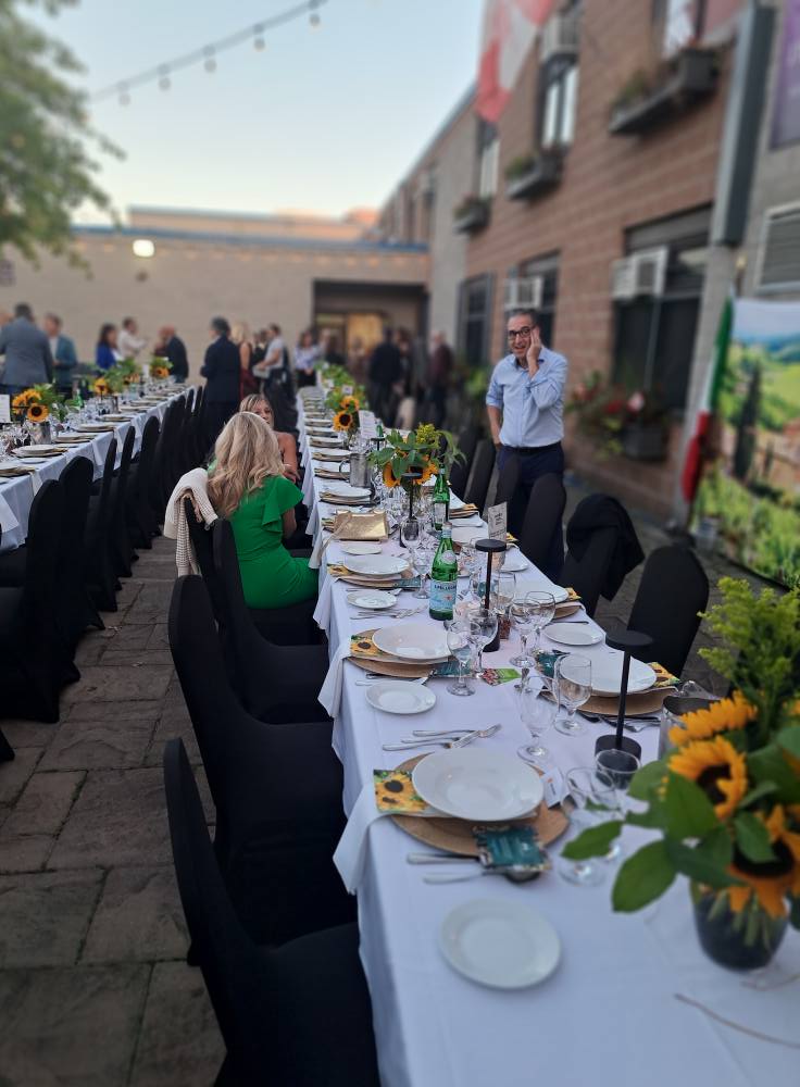 Elegant outdoor dining setup with long tables and floral decorations.