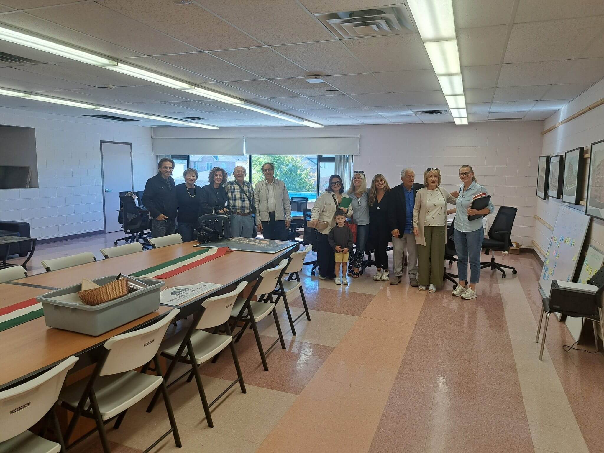A group photo of people in a classroom setting with tables and chairs.