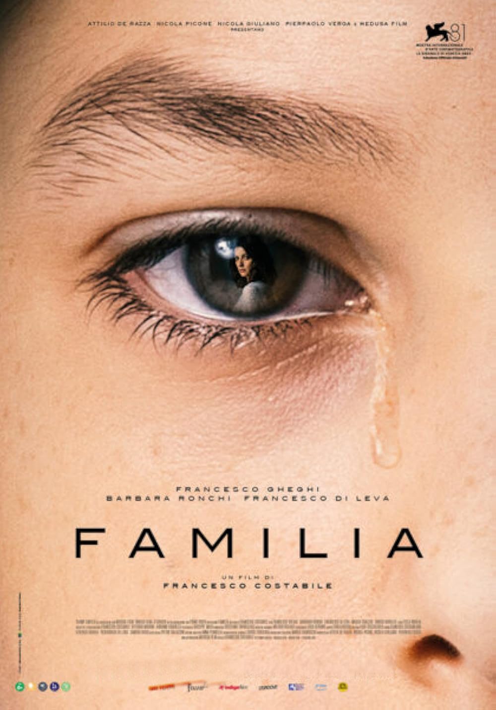 Close-up of teary eye, "Familia" movie poster.